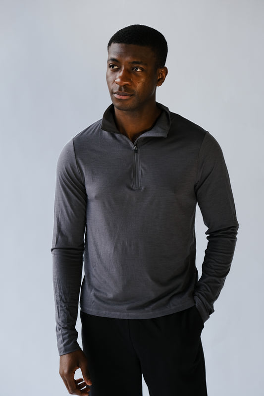 Man wearing a dark gray long-sleeve shirt against a light gray background