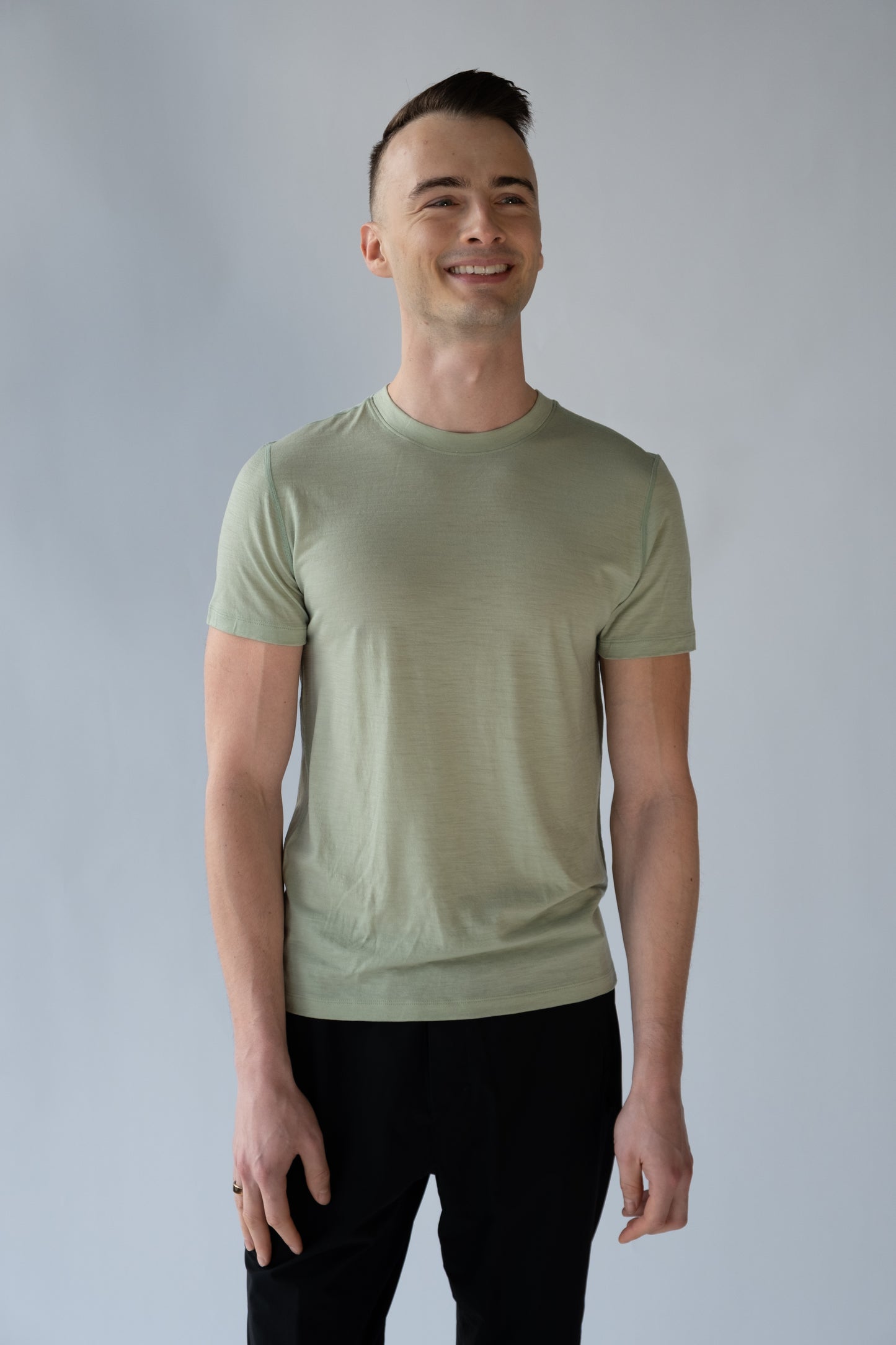 Man wearing a light green t-shirt against a plain background