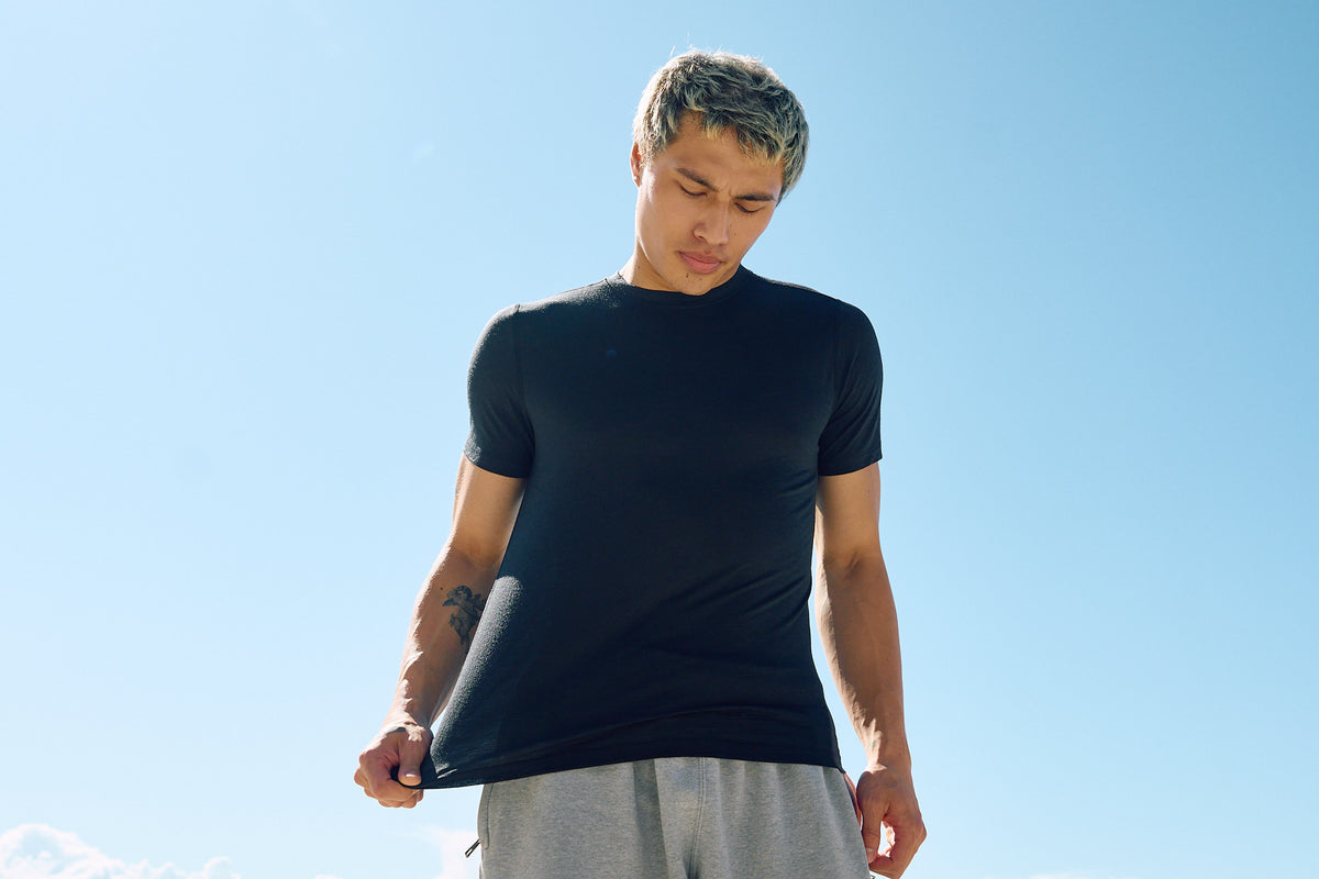 man pulling on merino wool t-shirt