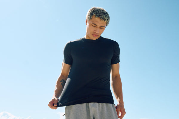 man pulling on merino wool t-shirt