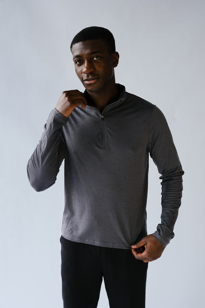 Man wearing a gray long-sleeve shirt against a plain background
