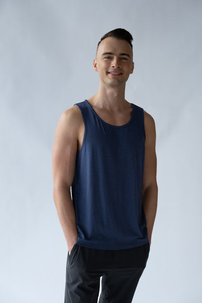 Man wearing a navy tank top against a plain background